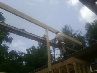 Carpenter setting a ridge beam over a new addition frame — Ice Dam Removal by Roofing Brothers in Allen