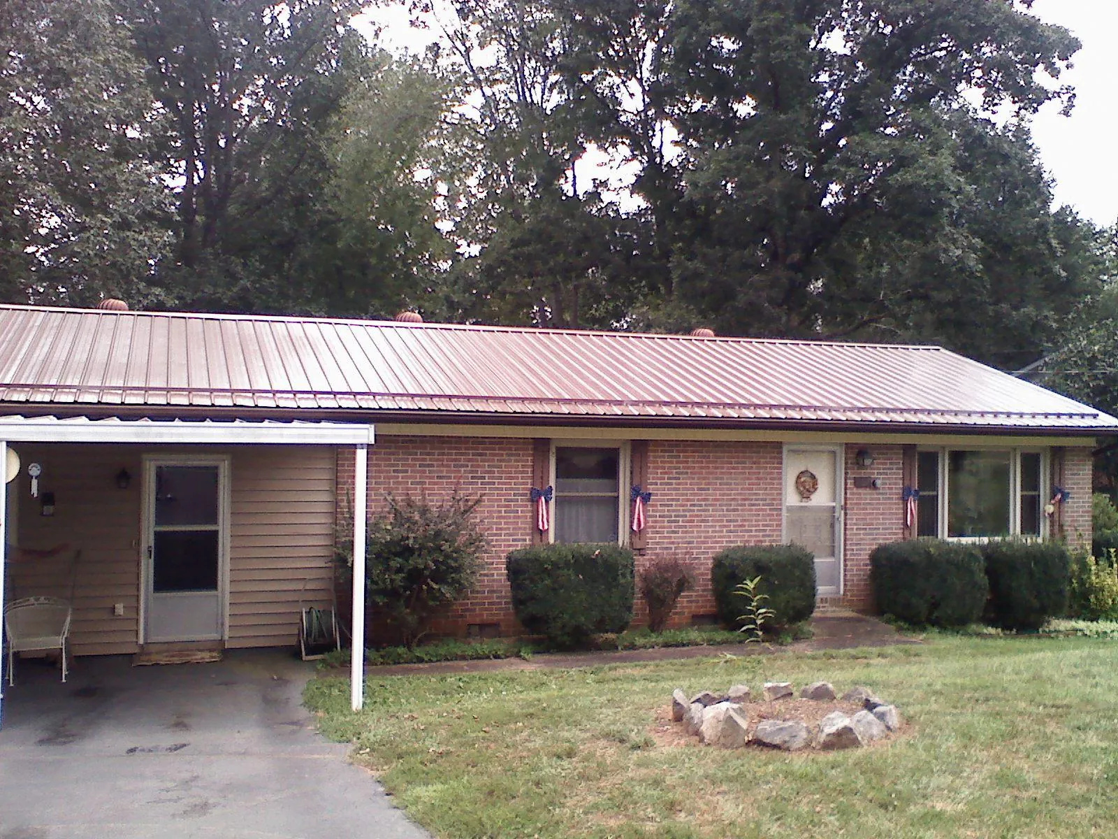 Bronze metal roof and carport on a brick ranch home — Roof Repair work by our crew in Allen