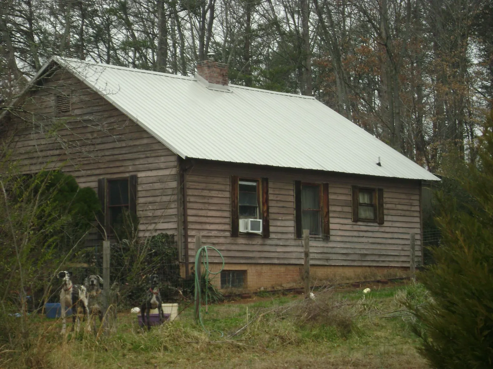 White metal roof on an old wood sided farmhouse, from a Metal Roof Installation job in Allen